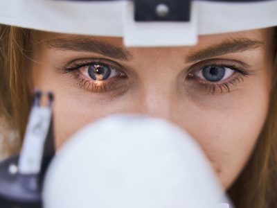 Close up of female person using ophthalmic equipment during eye examination